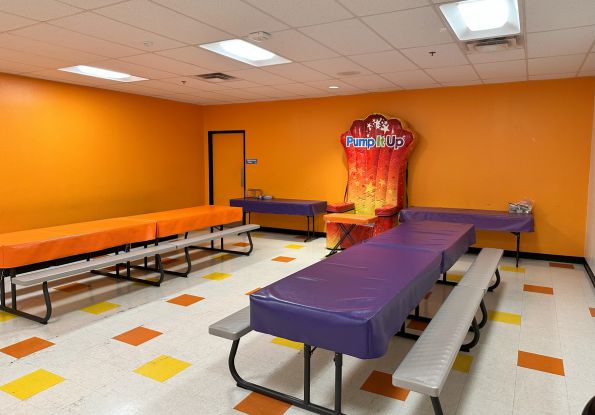 Pump It Up San Jose CA private party room filled with picnic tables and inflatable throne for birthday child to enjoy cake and pizza.