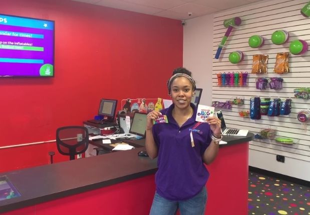 Pump It Up Assistant manager with guest of honor birthday sticker at Pump It Up 100% private kids birthday party place